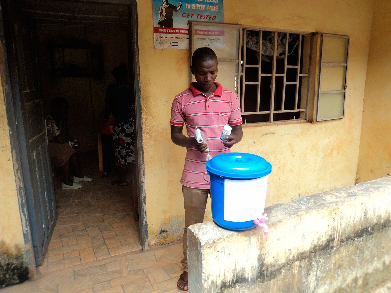 Equipement d'un centre de santé de Freetown avec un seau de désinfectant